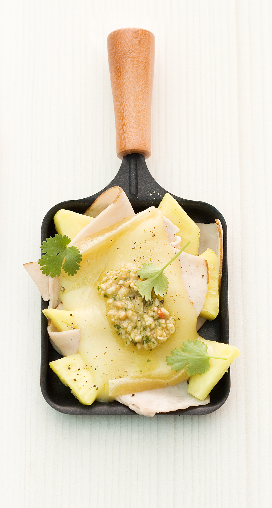 Raclette with turkey ham, pineapple and peanut and chili pesto